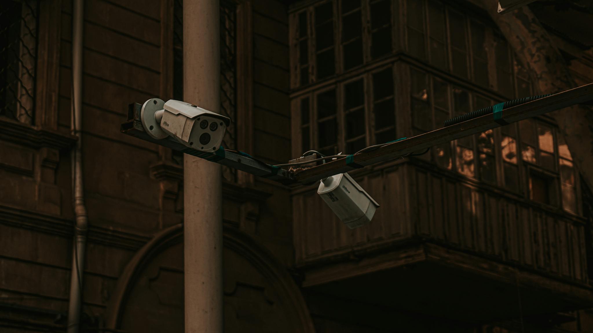 Street security cameras mounted on a pole in an urban environment, highlighting surveillance.